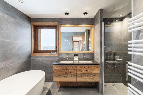 a bathroom with a sink and a mirror at Résidence Bois Du Ban - Chalets pour 10 Personnes 764 in le Praz