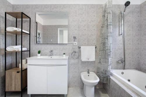 een badkamer met een wastafel, een toilet en een bad bij Sea La Vie Madeira in Ribeira Brava