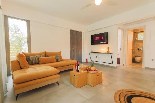 a living room with a couch and a tv at 4RosesVillas in Litochoro