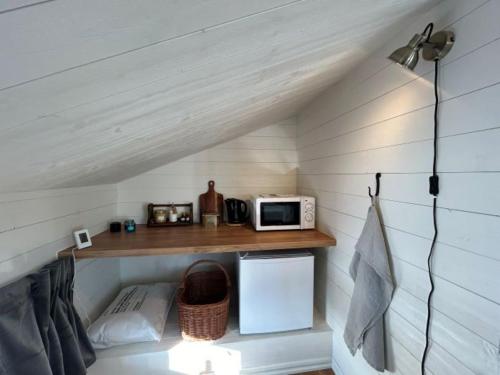 una pequeña cocina con estantería y microondas en Annas B&B en Järvsö