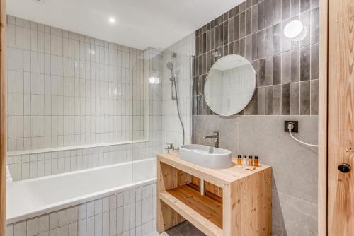 une salle de bain avec un lavabo, une baignoire et un miroir dans l'établissement Résidence Le Grand Bouquetin - 2 Pièces pour 6 Personnes MAE-0024, à Champagny-en-Vanoise
