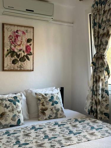 a bedroom with a bed with pillows and a window at Eski Datça Pansiyon in Datca