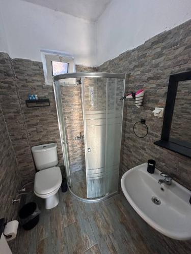 a bathroom with a shower and a toilet and a sink at Eski Datça Pansiyon in Datca