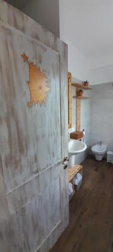 a wooden door in a bathroom with a toilet and a tub at SOL Y LUNA B&B in Aviatico