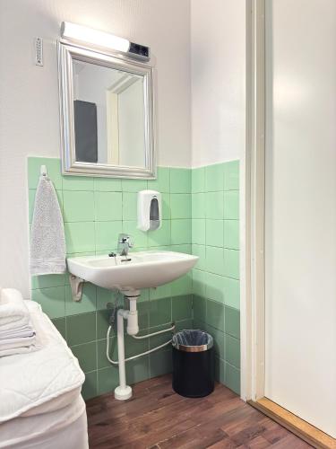 a bathroom with a sink and a mirror at Hostelli Matkustajakoti in Kuopio