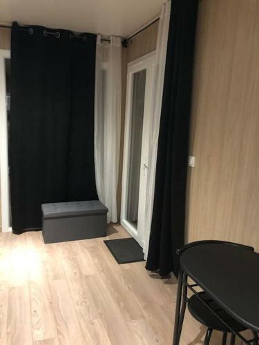 Cette chambre comprend un rideau noir, une table et une fenêtre. dans l'établissement studio GK15 GREENAPPART+ jardin SQY, Versailles.., à La Verrière