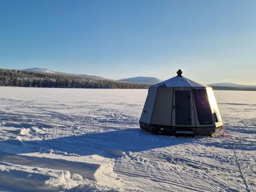 a tent sitting in the snow in a field at Aurora Hut Salla in Tikkala