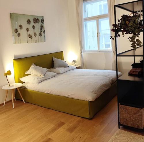 a bedroom with a large bed with a yellow headboard at Very cosy and quiet Apartment at Stadtpark in Vienna