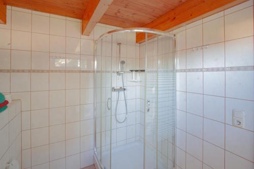a shower in a white tiled bathroom at hausANNA - casaNAUTICO in Ueckermünde