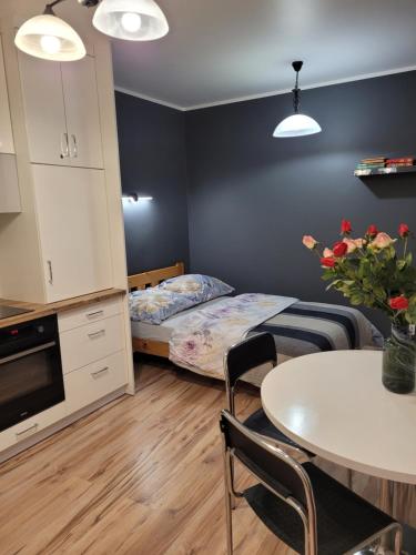 a bedroom with a bed and a table and a table and chairs at Gotycki Duch in Toruń