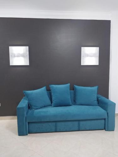 a blue couch in a room with two pictures on the wall at The Sharm House in Sharm El Sheikh