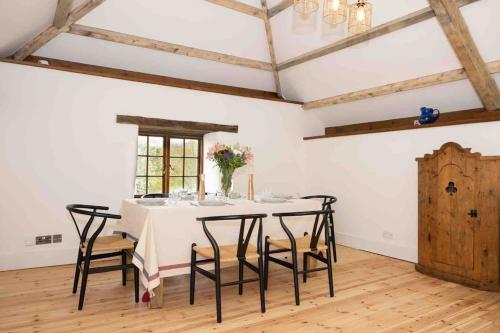 a dining room with a white table and chairs at Spacious country retreat in the heart of Devon. in Crediton