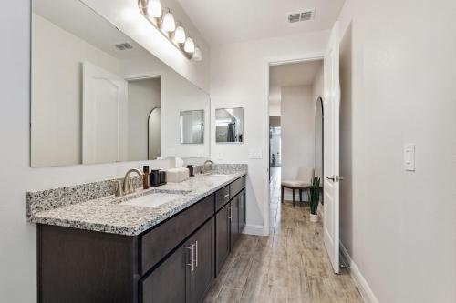 a bathroom with two sinks and a large mirror at Modern 5BR Getaway, PS5 & Board Games - Port St. Lucie, Florida in Carlton