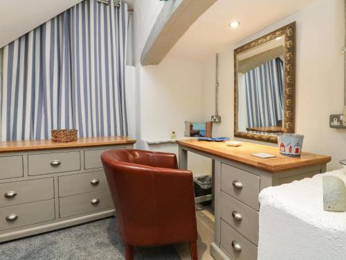 a bedroom with a desk and a mirror and a chair at Blue Bay in Lynton