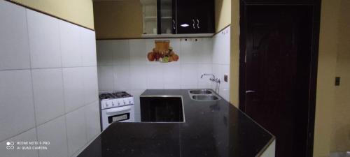 a kitchen with a black counter top and a stove at Hostal Cadena in Tupiza