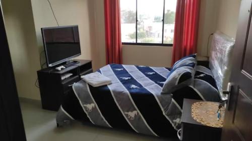 1 dormitorio con 1 cama y TV de pantalla plana en Hostal Cadena en Tupiza