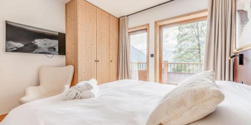 une chambre avec un lit blanc et une fenêtre dans l'établissement Résidence Le Grand Bouquetin - 3 Pièces pour 6 Personnes MAE-9954, à Champagny-en-Vanoise