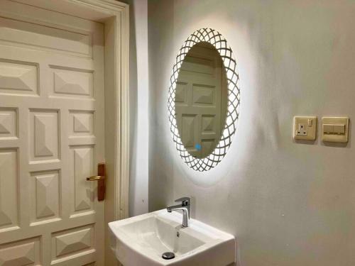 a bathroom with a sink and a mirror on the wall at APT 202 5 Twin Beds in Sulţānah