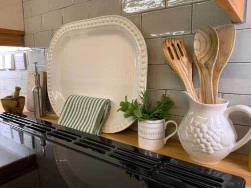 a kitchen counter with plates and utensils on it at Unique 17c listed Barn in a Shropshire hamlet. in Albrighton