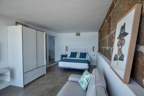Un dormitorio con una cama y un sofá en una habitación. en Apartamento Narcisa, en El Golfo