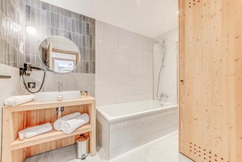 une salle de bain avec un lavabo, une baignoire et un miroir dans l'établissement Résidence Le Grand Bouquetin - 2 Pièces pour 6 Personnes MAE-9964, à Champagny-en-Vanoise