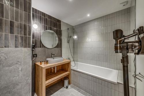 une salle de bain avec un lavabo, une baignoire et un miroir dans l'établissement Résidence Le Grand Bouquetin - 3 Pièces pour 6 Personnes MAE-9984, à Champagny-en-Vanoise