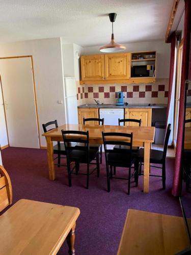 une cuisine et une salle à manger avec une table et des chaises dans l'établissement Résidence Cristallines - 3 pièces 6 personnes MAE-0054, à Orcières