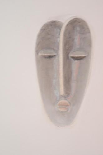 a wooden mask hanging on a white wall at The Buena Vista Kandy in Kandy