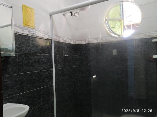 uma casa de banho com um chuveiro e uma porta de vidro em Sítio Conquista Feliz em Nova Iguaçu