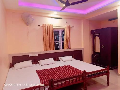 a bedroom with a large bed with a ceiling at geo gardens residency in Alwaye