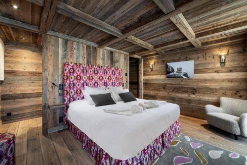 um quarto com uma cama grande e uma cadeira em Résidence Nanook - Chalets pour 15 Personnes 444 em Saint-Martin-de-Belleville