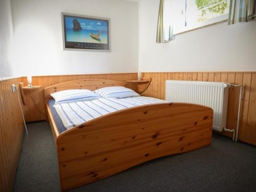 a bedroom with a wooden bed in a room at Ferienwohnung Struve Nr 2 in Petersdorf auf Fehmarn