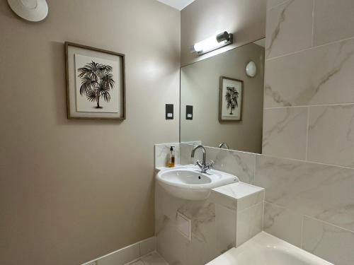 a white bathroom with a sink and a mirror at Goswell House in Windsor