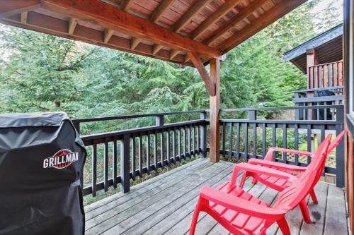 two red chairs sitting on a deck on a cabin at The Cabins at Terrace Beach in Ucluelet