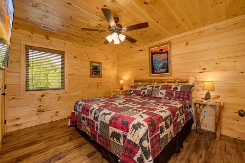 a bedroom with a bed in a log cabin at Sweet Mountain Memories Relax affordably cozy cabin with hot tub, game room, and mountain views! in Cosby