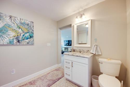 a bathroom with a toilet and a sink and a mirror at Lush Punta Gorda Escape Private Pool and Lanai in Punta Gorda
