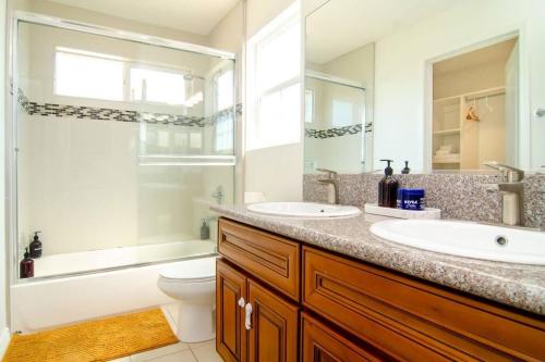 La salle de bains est pourvue de 2 lavabos, de toilettes et d'une douche. dans l'établissement Up to 20% off weekly stay 3BR 2.5 miles to airport, à Ontario