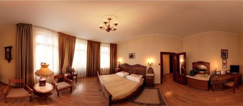 a bedroom with a bed and a table and a desk at Hotel BAST Wellness & SPA in Inowrocław
