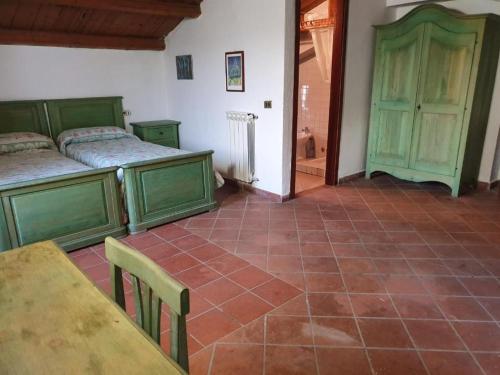 a room with two beds and a table and a dining room at Agriturismo Radici Contadine in Bisaccia