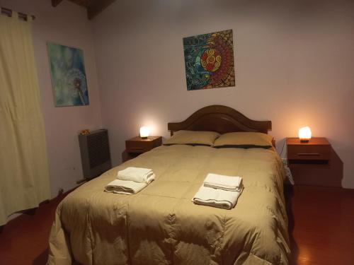 um quarto com uma cama grande e toalhas em Shanti em Esquel