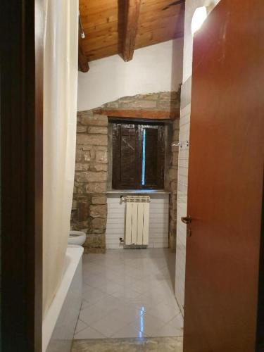 a bathroom with a tub and a toilet and a window at Agriturismo Radici Contadine in Bisaccia