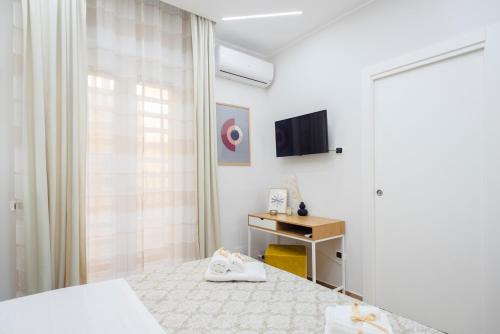 a hotel room with two beds and a television at MarGab B&B in Naples