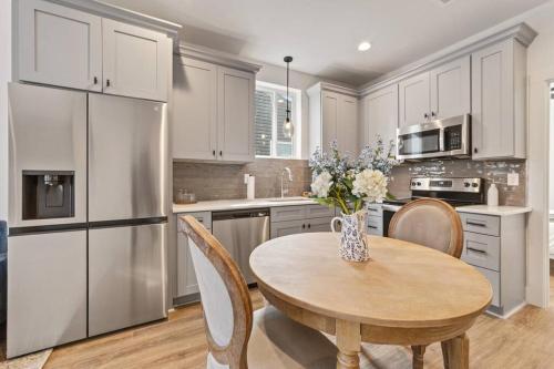 a kitchen with a table with a vase of flowers on it at Cypress House*Cozy, Chic, and yours to book now! in Lafayette
