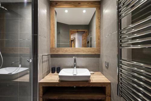 a bathroom with a sink and a mirror at Résidence Les Cimes Blanches - 4 Pièces pour 6 Personnes 414 in Courchevel