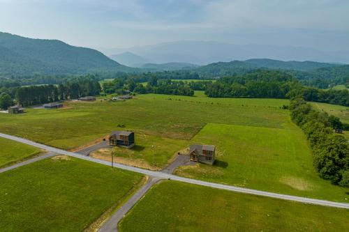 an aerial view of a field with houses and a road at Misty Morning Meadow Breathtaking Smoky Mountain Cabin with Hot Tub, Views, & Free Tickets in Cosby