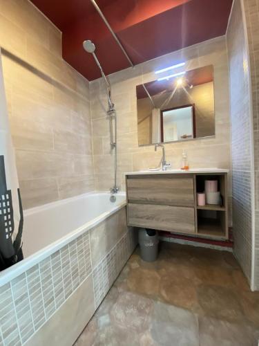 une salle de bain avec une baignoire, un lavabo et un miroir dans l'établissement Résidence Neves - VAL THORENS location: magnifique studio pour 4 dans quartier animé MAE-3794, à Val Thorens