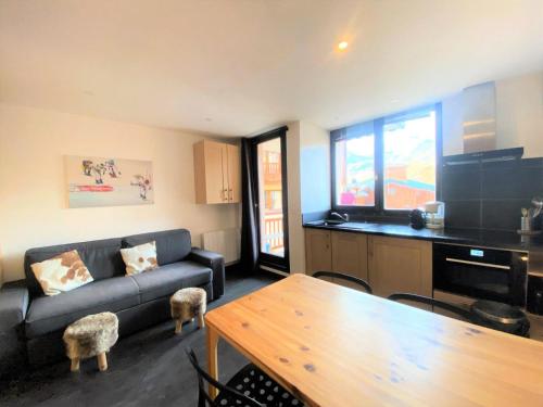 un salon avec un canapé et une table dans l'établissement Résidence Joker - très bel appartement rénové à VAL THORENS MAE-3774, à Val Thorens