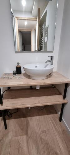een badkamer met een wastafel en een spiegel bij L'Ethnic Chic Wifi, Netflix, Disney, Coeur de Bastide in Villefranche-de-Rouergue
