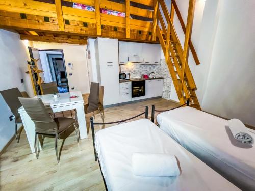 a room with two beds and a table and a kitchen at House Brennero 29 in Carpi