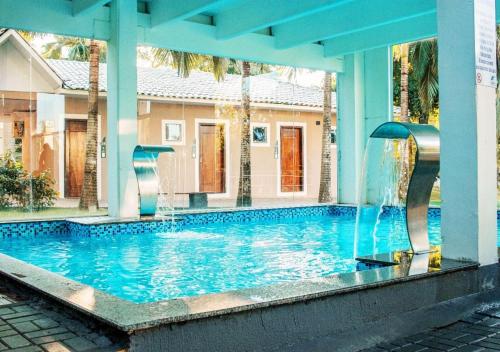 - une piscine avec une fontaine en face d'une maison dans l'établissement Maestro Thermas Park Hotel, à Francisco Beltrão